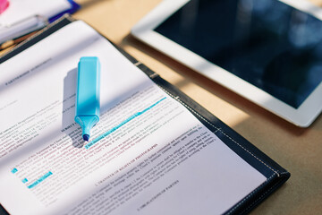 Tablet computer and contract with blue highlighter pen on office table