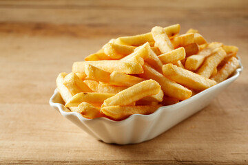 Plate with fried potatoes on wooden table