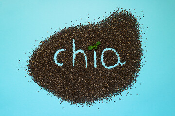 Blue background with chia seeds. Chia lettering with mint leaves. Superfood and a healthy lifestyle.
