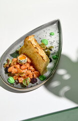 Salmon tartar with quail egg and toast bread. Raw fish tartare restaurant appetizer on white table...