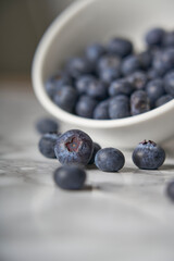 A group of fresh blueberries on a white and black marble table. 