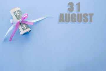 calendar date on blue background with rolled up dollar bills pinned by blue and pink ribbon with copy space. August 31 is the thirty-first day of the month