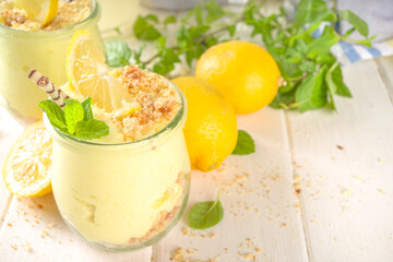 No baked homemade lemon cheesecake with mint in small vintage jars