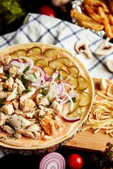 closed pizza on a round wooden board on a black background