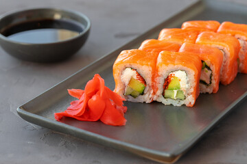 Philadelphia sushi roll served on black ceramic plate