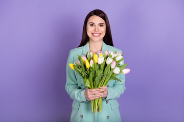 Photo of positive happy pretty lady hold tulips flowers smile present gift isolated on purple color background