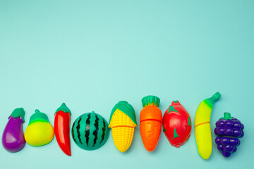 Creative pattern of toy fruits and vegetables on a pastel birch background. Minimal food concept.