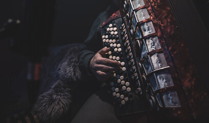 Close up a man plays the accordion in the studio.
