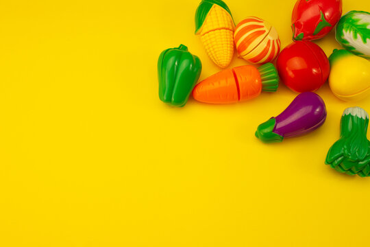 Creative Composition Of Toy Fruits And Vegetables On A Pastel Yellow Background. Minimum Summer Concept. Surrealism.