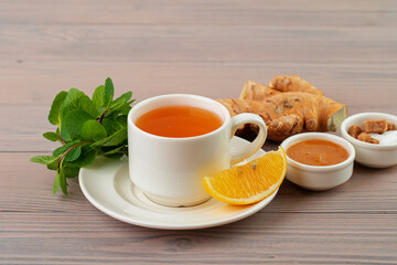 Cup of tea served with lemon and mint