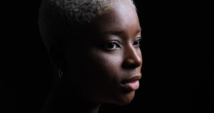 Face of thoughtful serious woman over black background