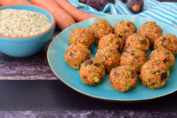 Carrot oat date energy balls. Gluten free and vegan food. Wooden background