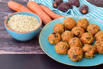 Carrot oat date energy balls. Gluten free and vegan food. Wooden background