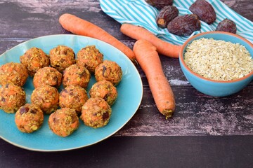 Carrot oat date energy balls. Gluten free and vegan food. Wooden background