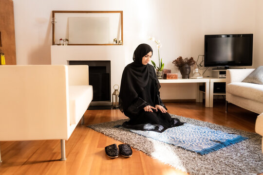 Young muslim woman kneeling during prayer
