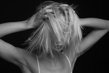 black-and-white portrait of a blonde on a black background.