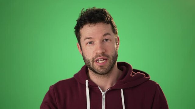 Close up head shot portrait man applicant on green screen chroma key wave hand greeting remote employer hr managers answers questions feels confident during job interview by video call app concept