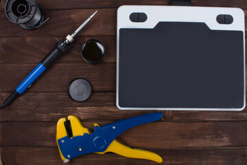 Flatlay on the topic of radio electronics repair. Soldering iron and wire stripper tool. Place for text.