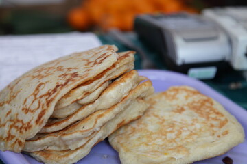 Russian traditional pancakes on a plate closeup on blurred cash register background, the national pagan holiday of Maslenitsa