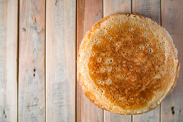 Appetizing thin pancakes on a wooden background. Russian food for the holiday Maslenitsa.