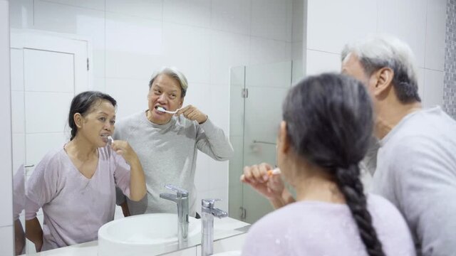 Senior couple brushing teeth in the bathroom