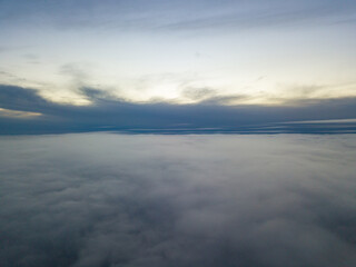 Fototapeta na wymiar High flight above the clouds at sunset. Aerial view.