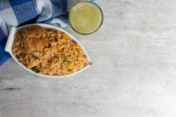 Rice with chicken, traditional Brazilian culinary named galinhada, and pineapple with mint juice.