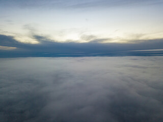 High flight above the clouds at sunset. Aerial view.