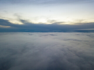 High flight above the clouds at sunset. Aerial view.