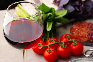 Glass of red wine with appetizer on table close up