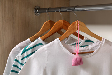 Scented sachet and clothes hanging in wardrobe