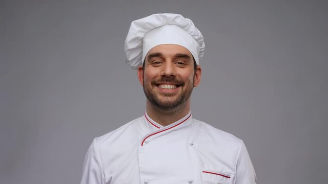cooking, culinary and people concept - happy smiling male chef in toque and jacket over grey background