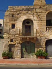 Fototapeta na wymiar Bardzo stary dom z zieloną bramą, Malta