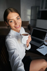 Smiling lady using smartphone for selfie during coffee break