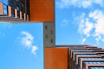 A view from below of tall office building towers connected at the top by a passage against the sky...