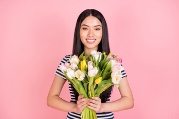 Photo portrait of brunette girl smiling happy received tulips bunch isolated on pastel pink color background