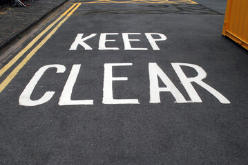 Close Up of 'Keep Clear' Sign Painted on Tarmac Road Surface 