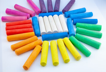 Chalks in a variety of colors on white background. Big chalk stick close up. Rainbow colorful pastel for preschool children