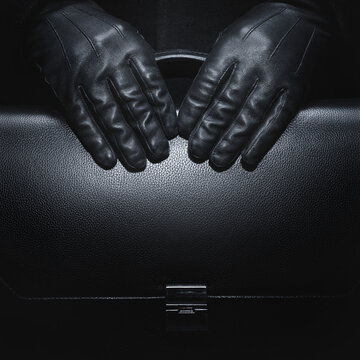 Black leather gloves. Briefcase in black leather. Business style.