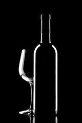 red wine bottle and wine glass isolated on black background