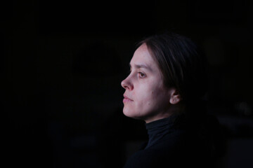 Portrait of a girl in profile with an antique face surrounded by a black background 