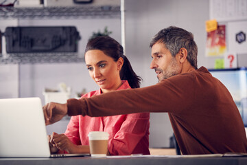 Male And Female Advertising Marketing Or Design Creatives Collaborating On Project In Studio