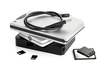 Group of external Hard disks and memory cards on white table. Data storage concept