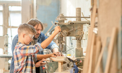 Teacher teaches the boy to work on the drilling machine. Empty space for text