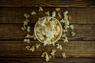 popcorn in a bowl, top view, on a wooden background