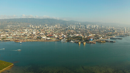 Aerial view of panorama of Cebu city with skyscraper, buildings and seaport with ships and ferries in the early morning. Philippines.
