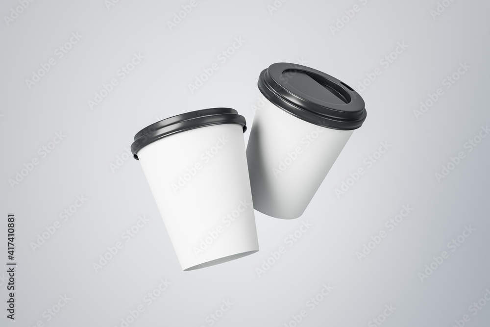 Poster two blank white paper mugs to go with black plastic caps levitating at abstract light background. mo