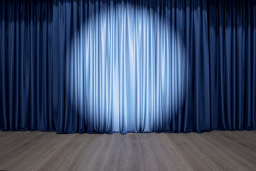 Round spotlight on blue curtain on the stage with wooden floor