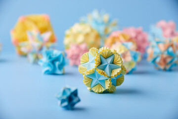 Set of multicoloar handmade modular origami balls or Kusudama Isolated on blue background. Visual...