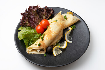 stuffed pancakes with meat with tomatoes and salad on a plate